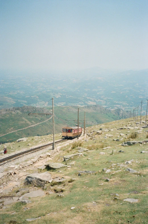 a train traveling on a train track on a hillside