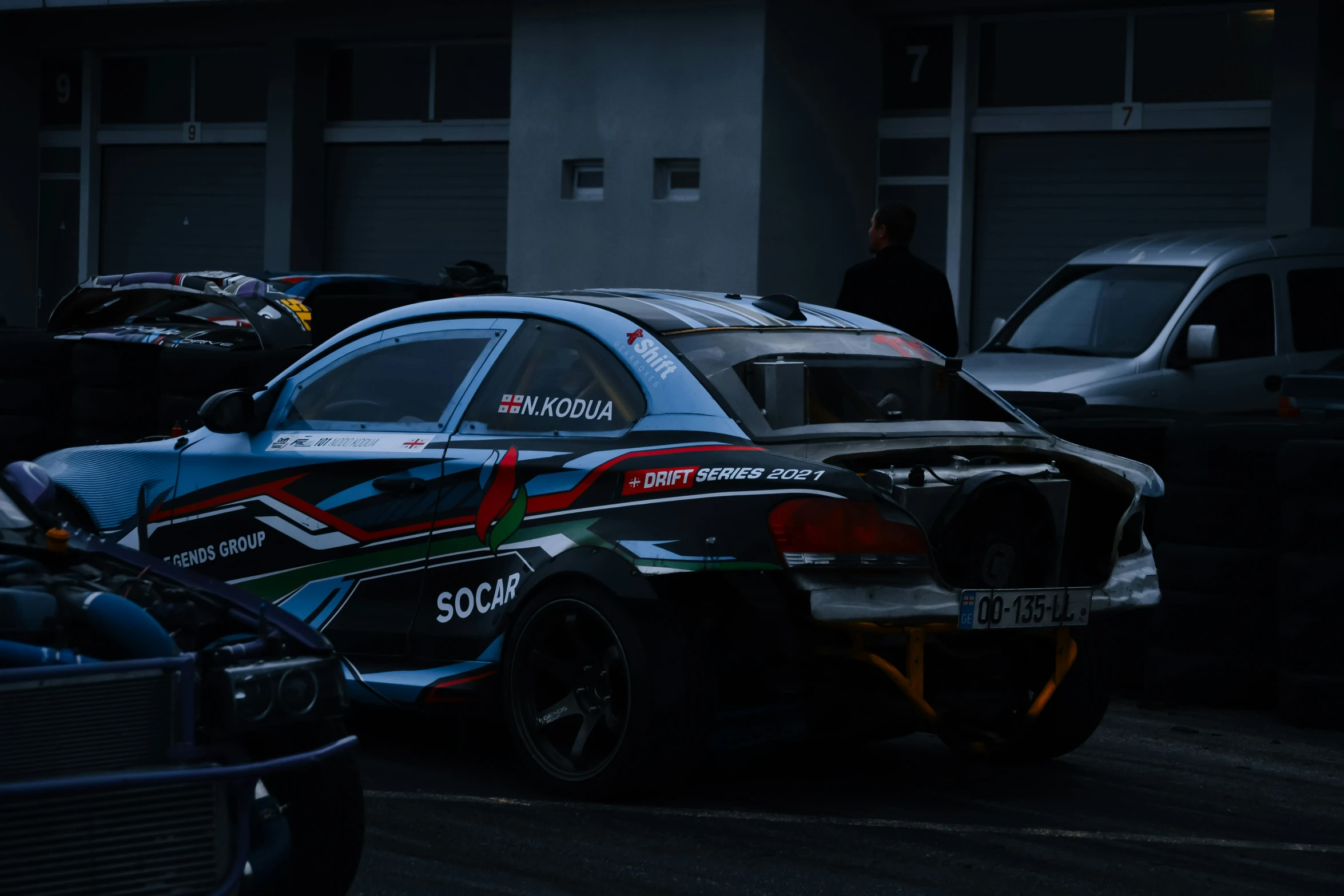 several colorful sports cars sit in a parking lot