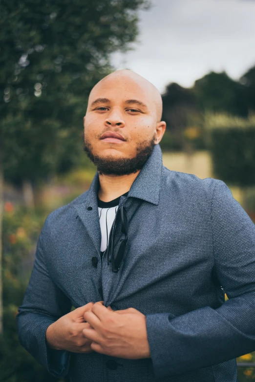 a bald man standing in the middle of an outdoor area