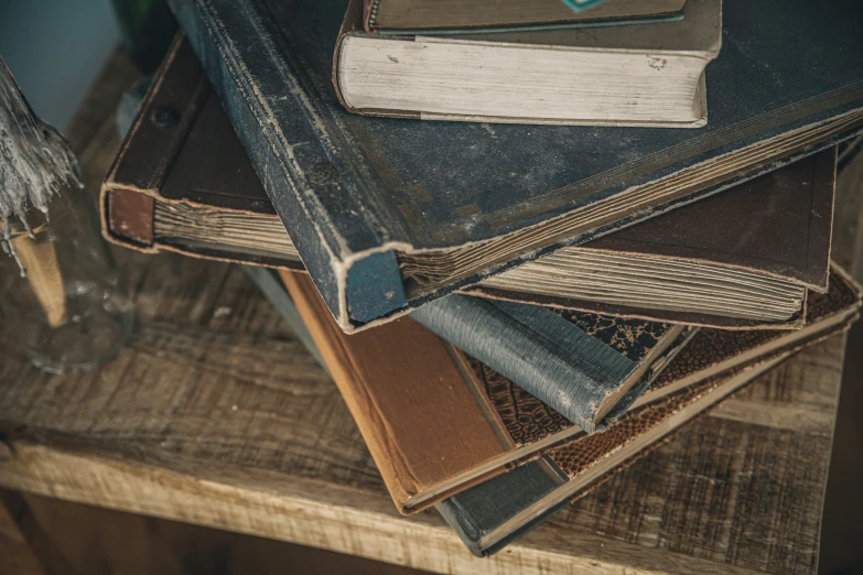 a stack of books sitting on top of a wooden table