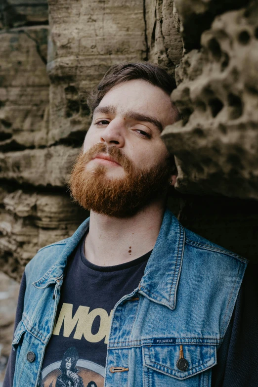 man looking up with his eyes open standing by the edge of cliff