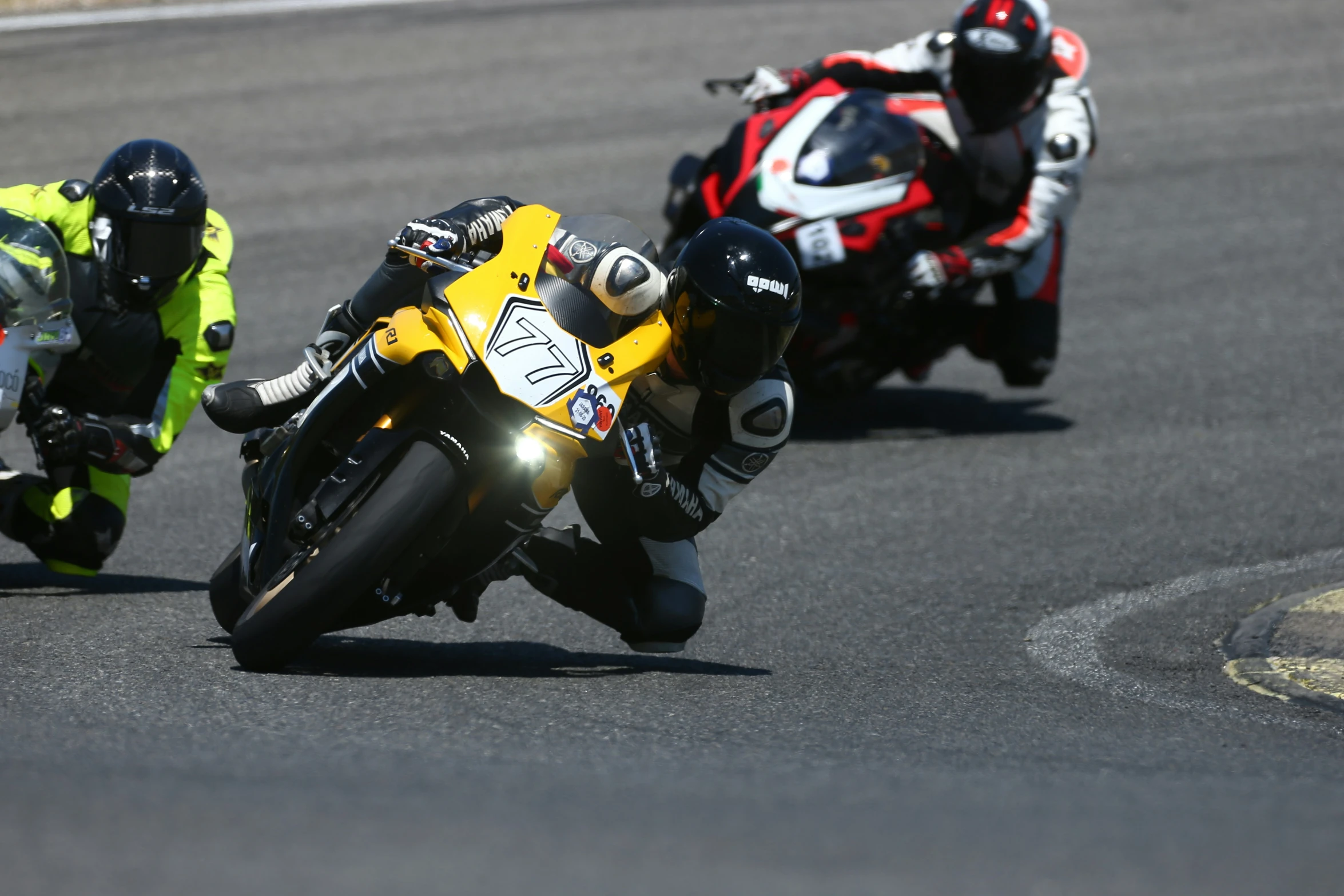 two people riding motorcycles in race while onlookers look on