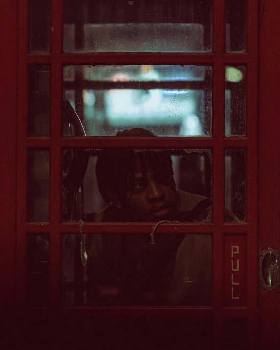 two people peeking through a window at night