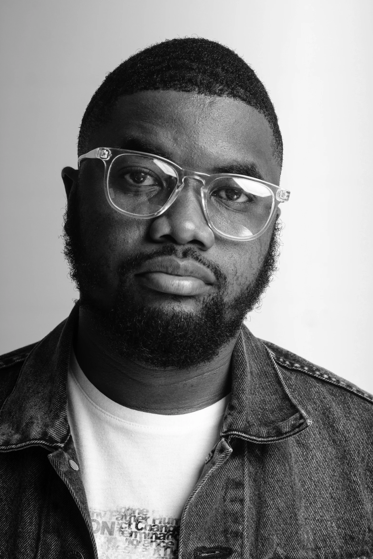 a man in glasses wearing a jean jacket