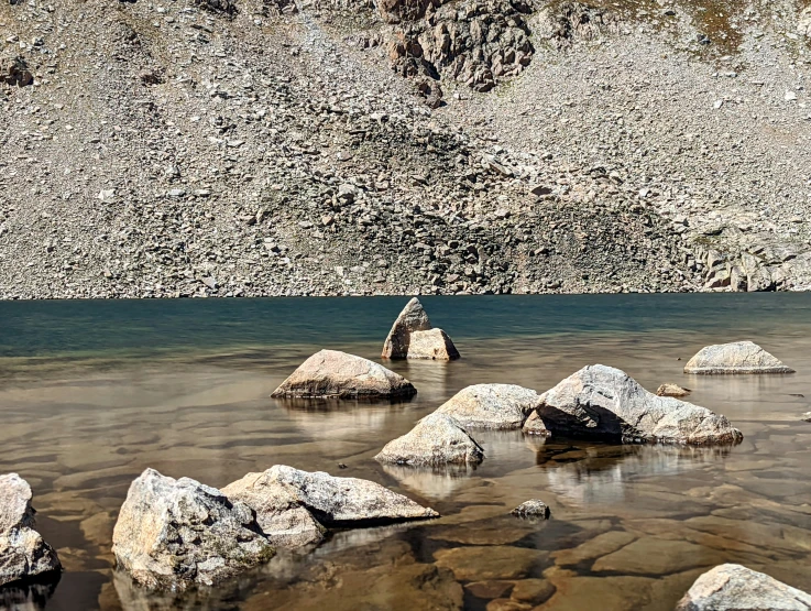 several large boulders in the water near rocks