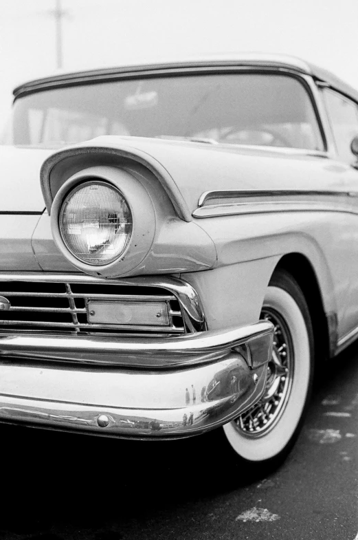 a close up view of the headlight and hood of a classic car