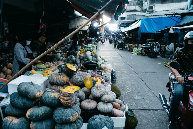 a man is riding a bike through a fruit stand