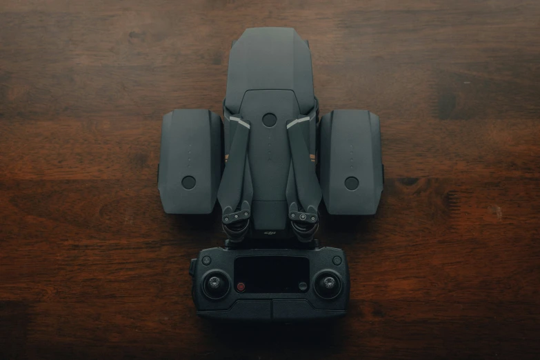 a gray camera is sitting on top of the wood table