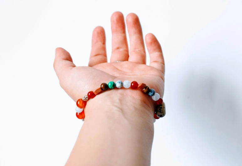 a woman's hand with various beaded jewelry celets