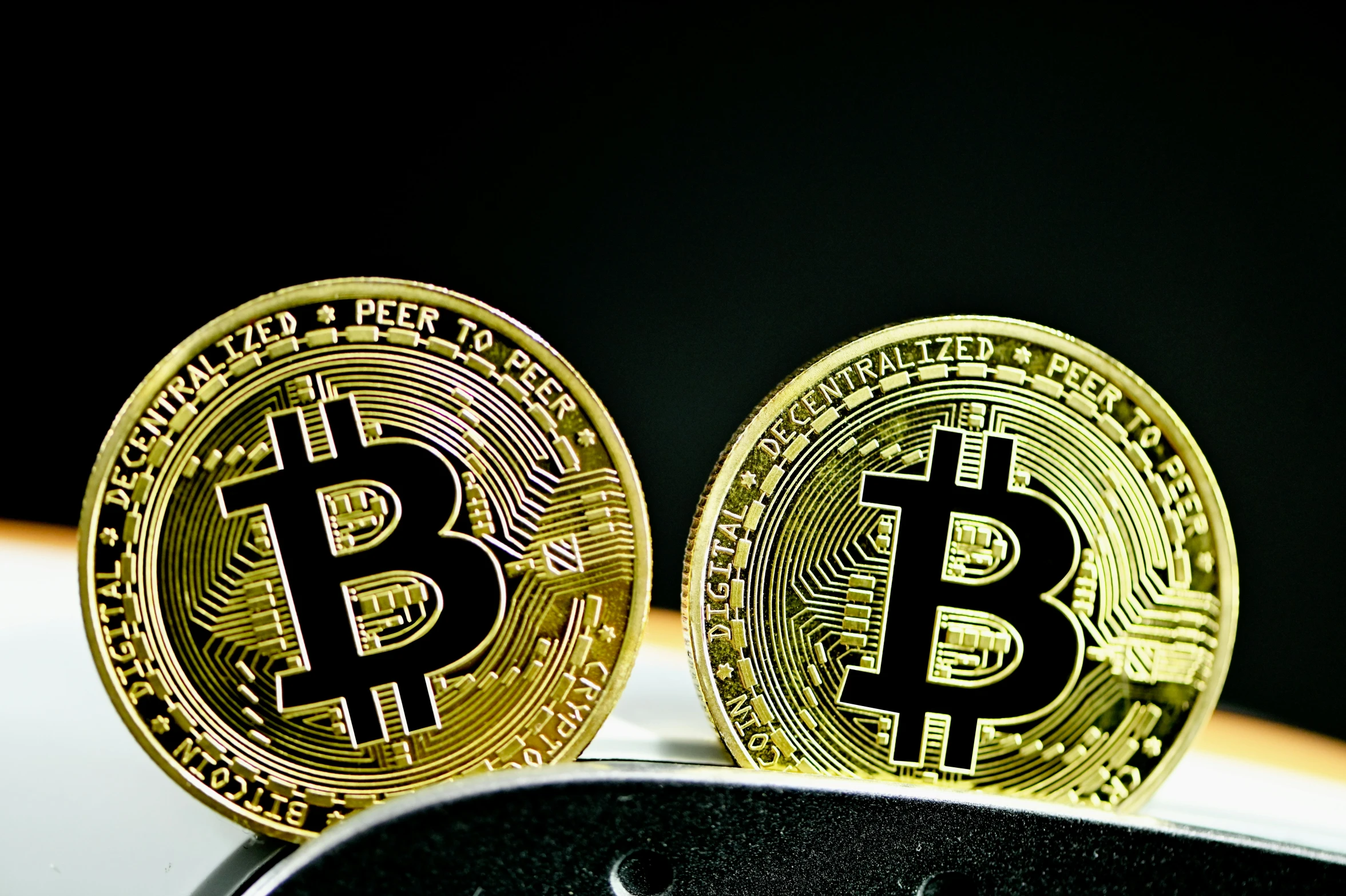 two gold bitcoins sitting on top of each other