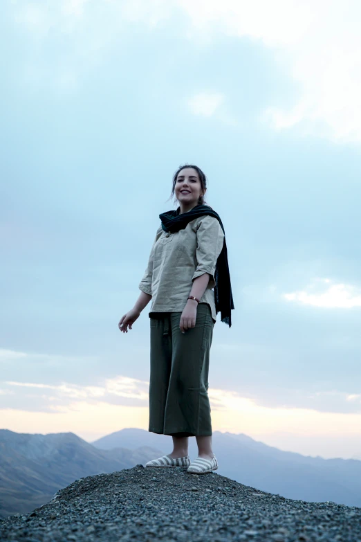 a woman stands on a rocky, rocky top