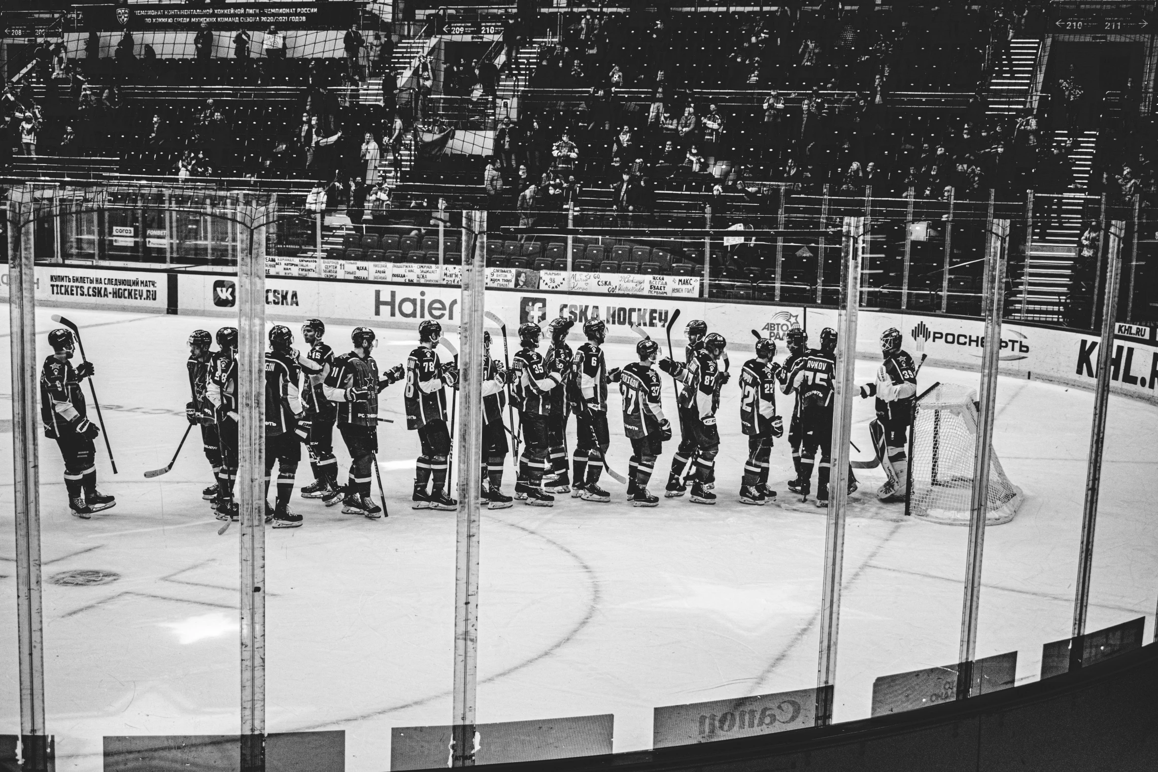 hockey players stand on the ice during a game