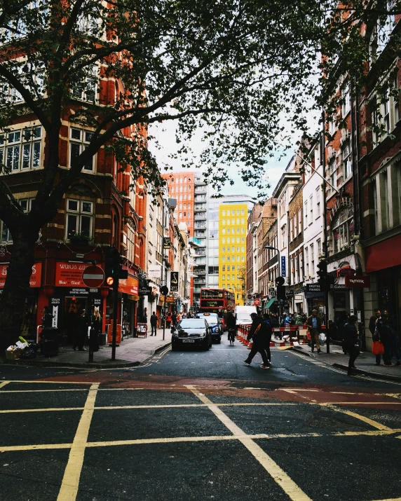 two people are walking across the street holding umbrellas