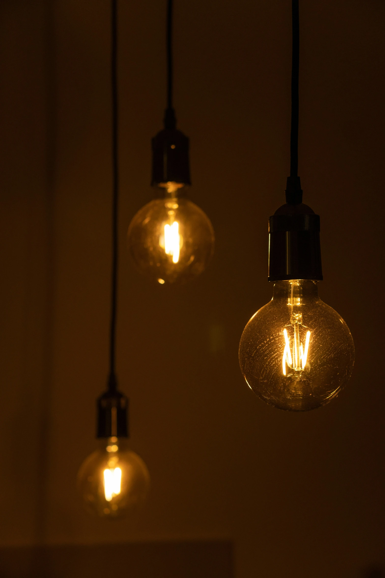 three dim lit bulbs hanging from a ceiling