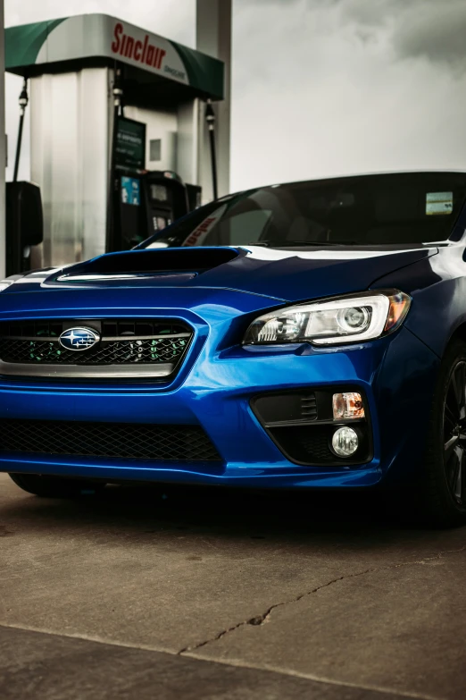 blue subaruce cars at the gas pump