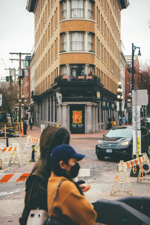 people walking down a street in front of tall buildings