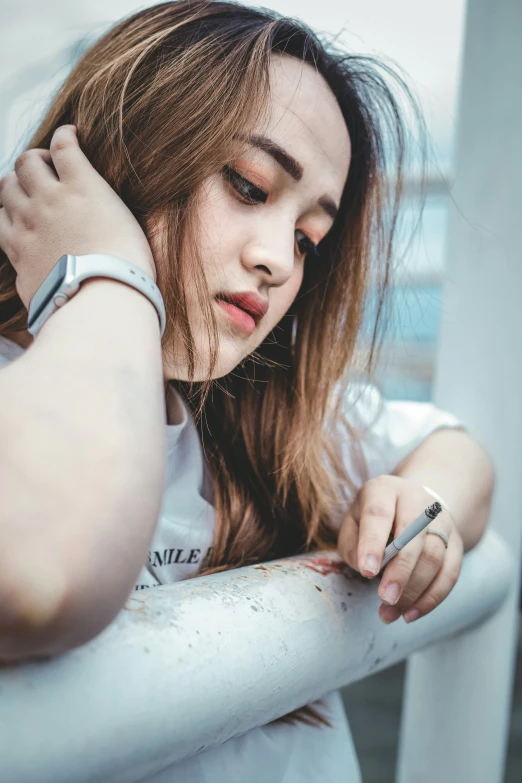 a woman is posing by a building and holding her hand on her ear