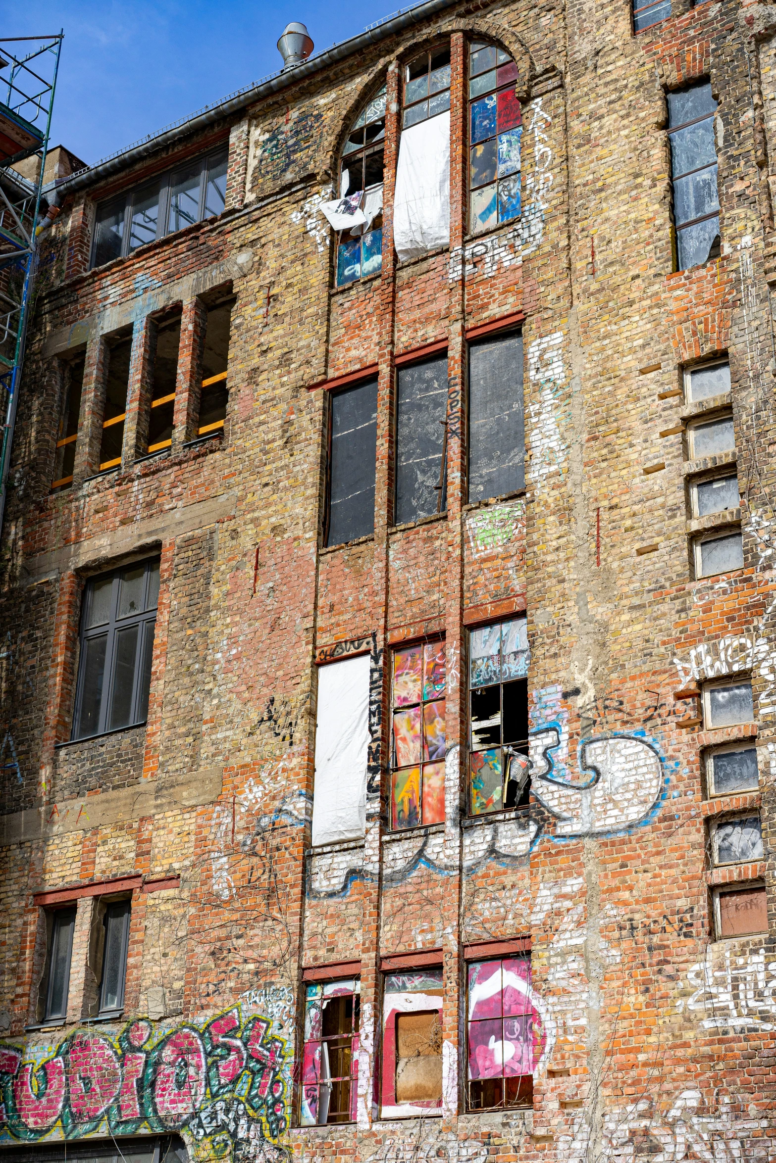 graffiti covered wall and windows in an old brick building