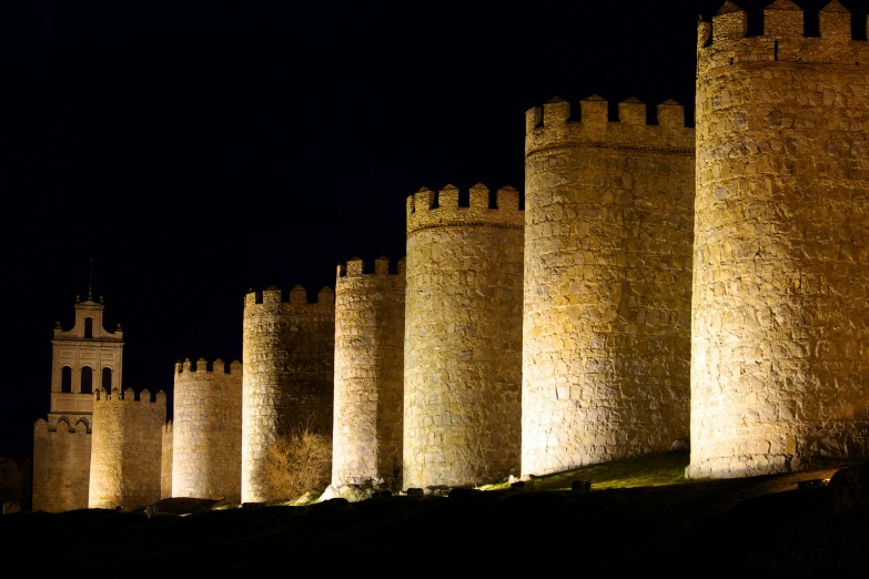 a group of castle like structures at night with lights on