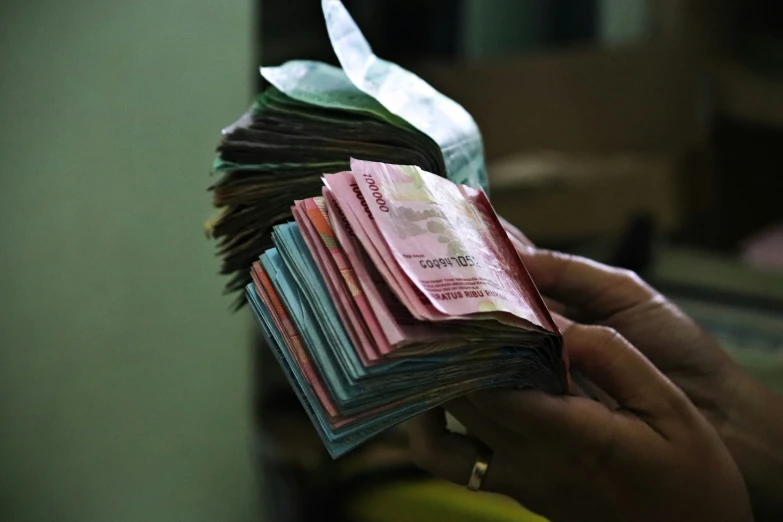 a man holding several bundles of money