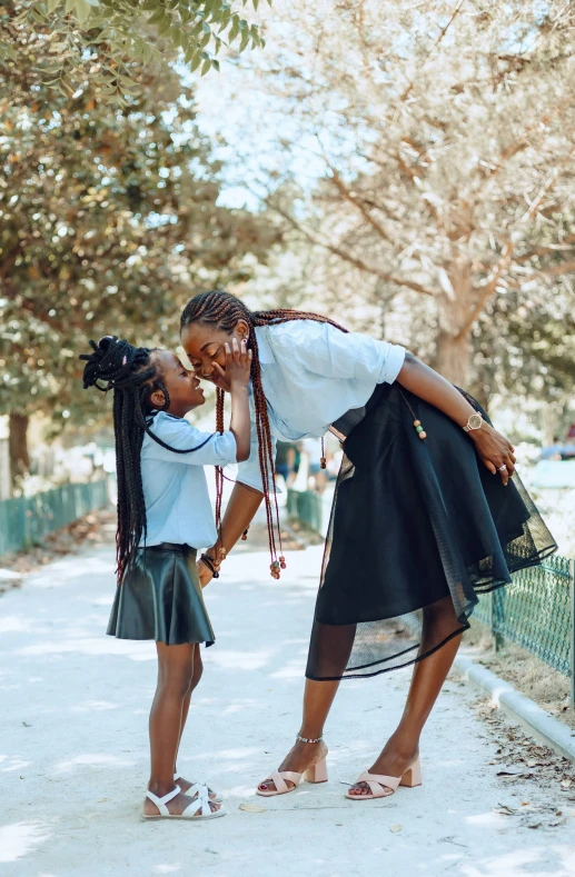 a young woman leaning on another woman who is touching her