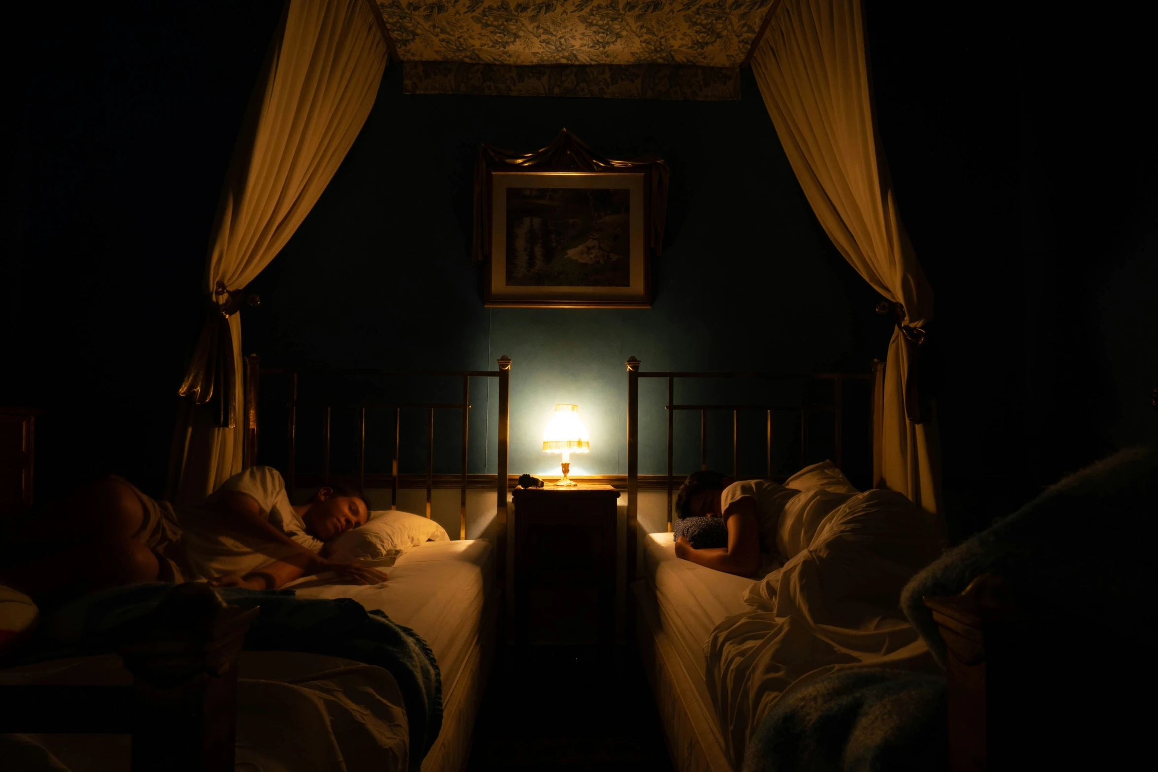 there are people sleeping in a bed lit by lamps