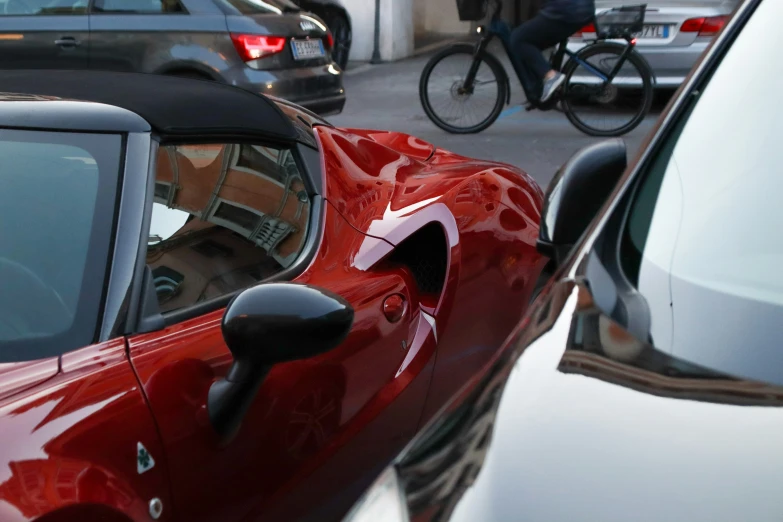 a closeup of a bike rider in the background as others ride their bikes and other cars