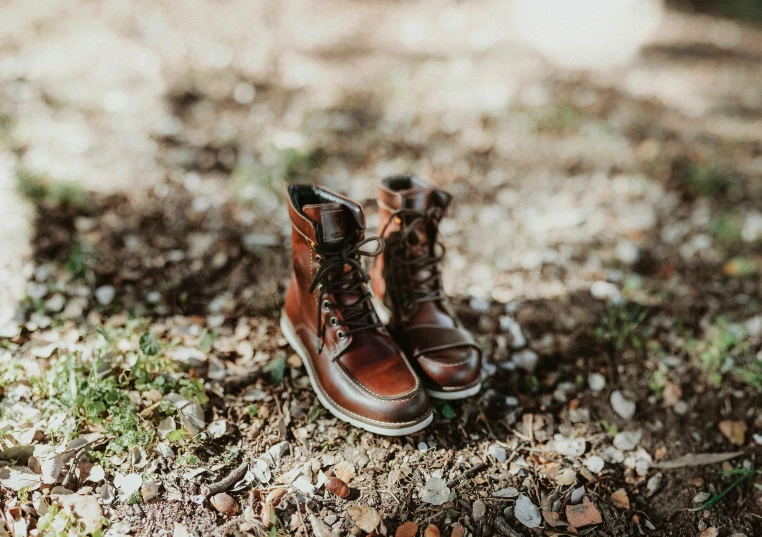 a pair of brown boots sitting in the grass