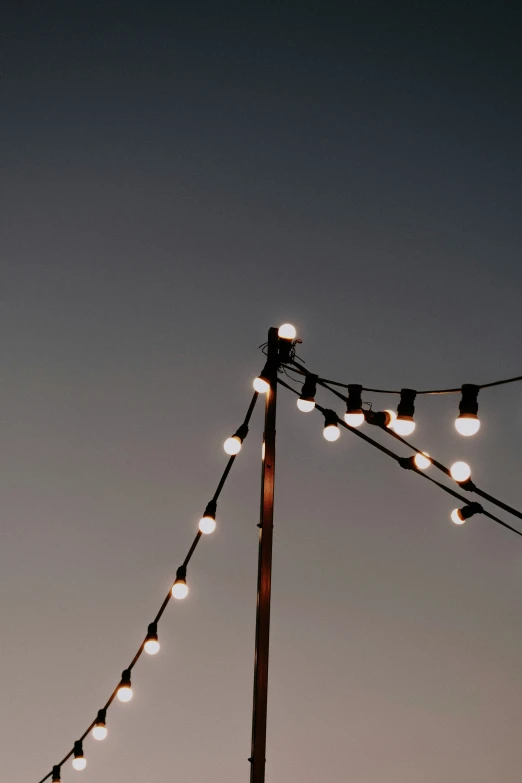 a clock on top of a wooden pole with many lights