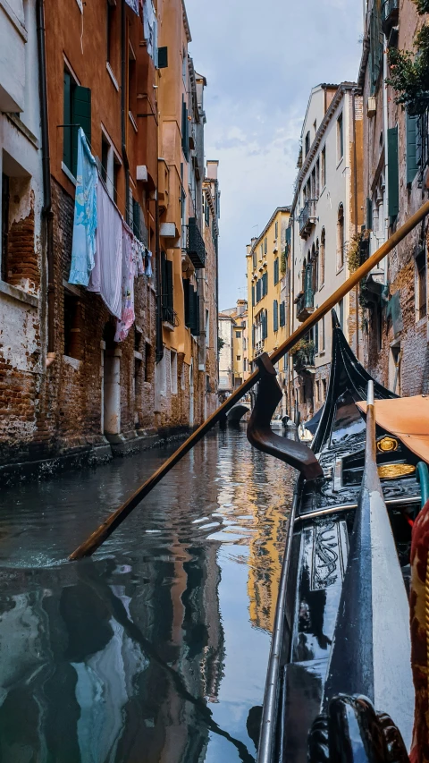 a rowboat on a canal with a long pole over it