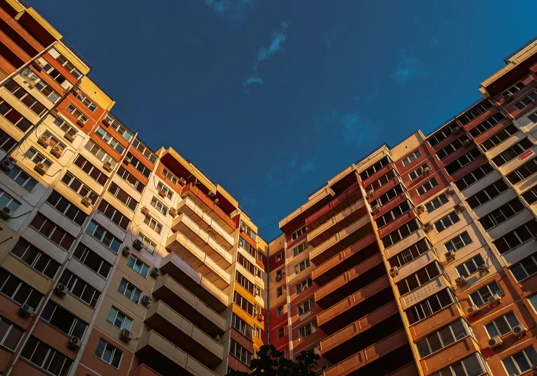 a couple of tall buildings sitting below a blue sky