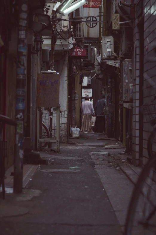 a dark alley that leads into the distance, with people in the center