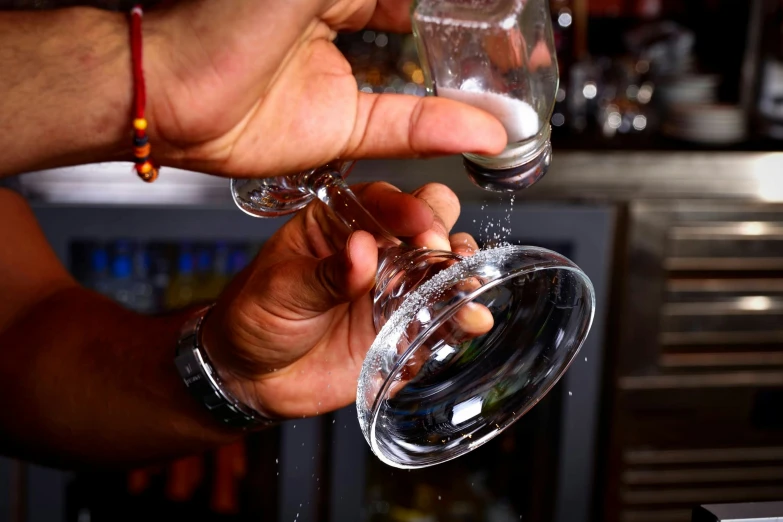 person drinking from a clear wine glass with liquid splashing out