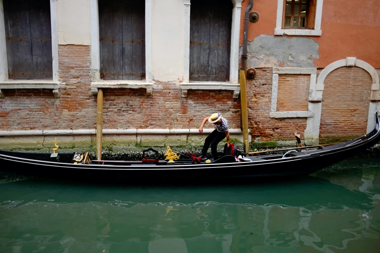 a man standing on top of a boat with a straw hat