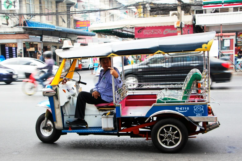 two men riding on a small motorized passenger vehicle