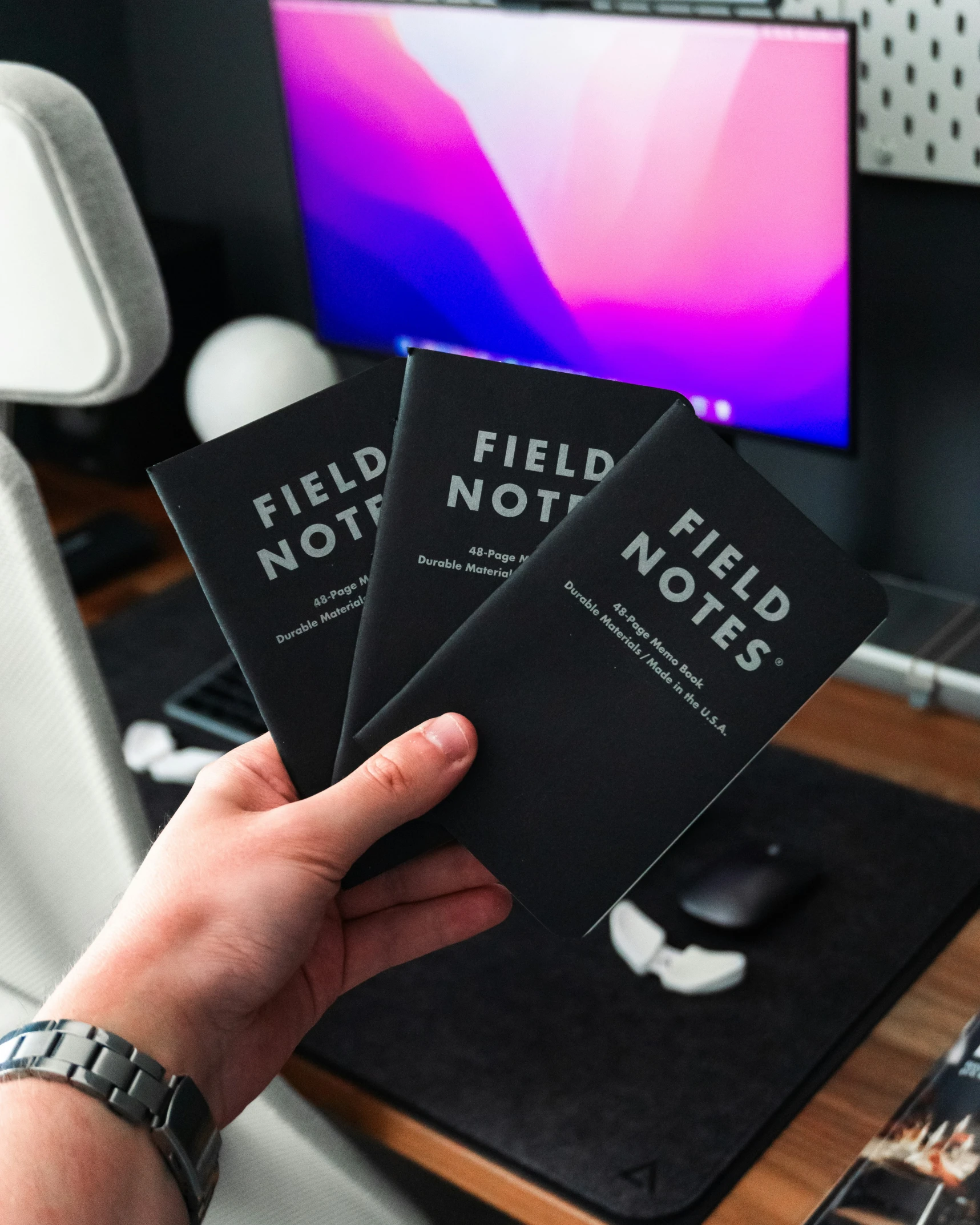 three small cards held in front of a computer