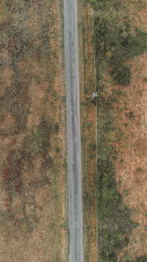 an aerial s of a road running through a field