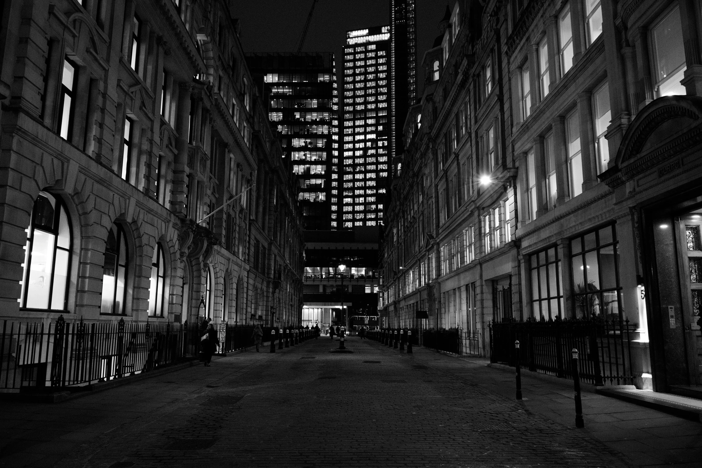 an empty city street at night with tall buildings