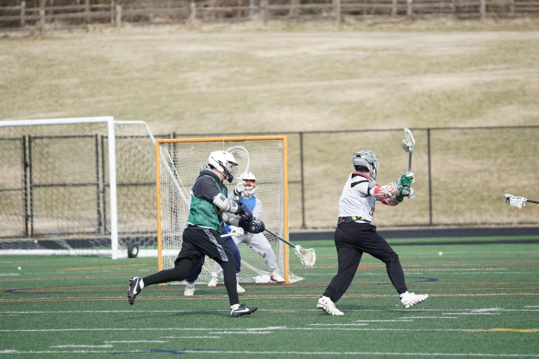 the young people are playing a game of lacrosse