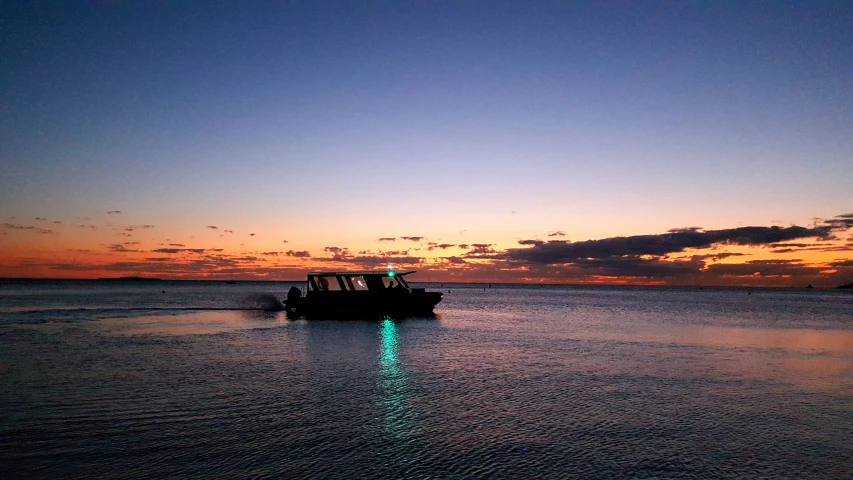 a boat traveling through the sea during the dusk