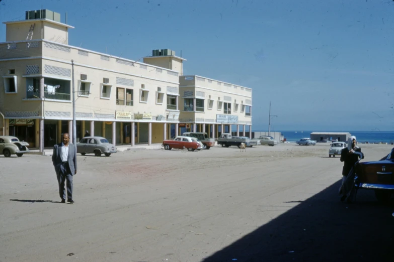 a man in a suit walking away from some cars