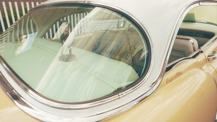 a reflection of an older gentleman sitting in a vintage car