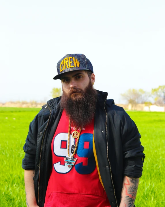 a man in a field, wearing a baseball cap