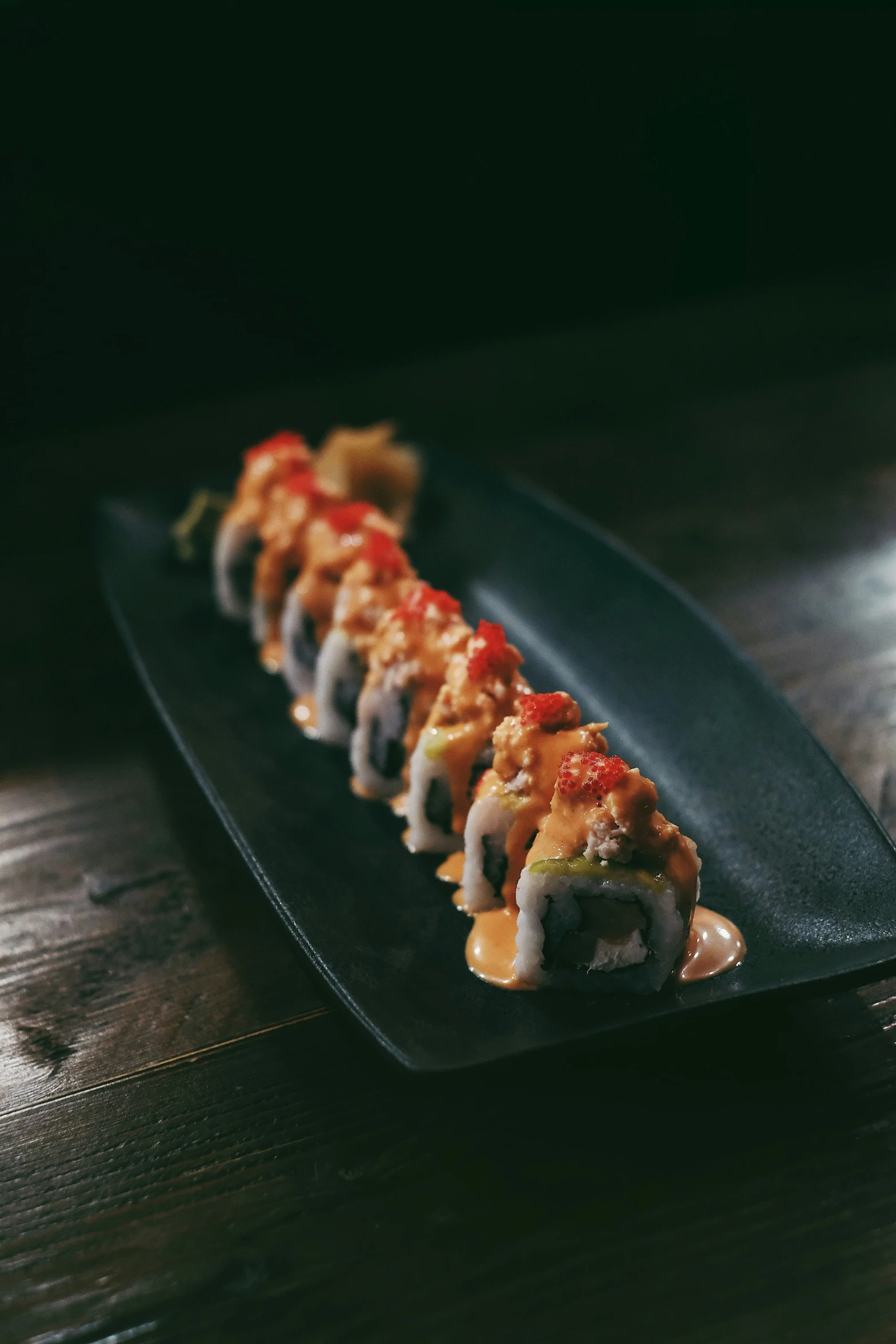 a sushi dish on a black plate