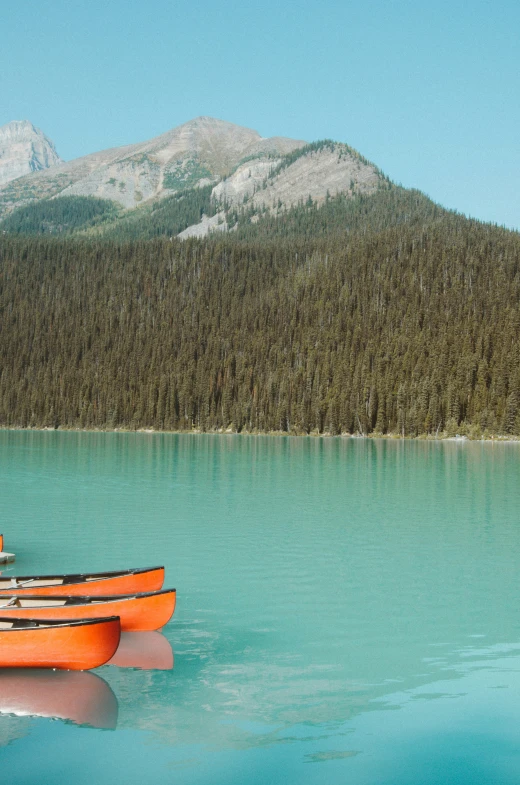 some boats are parked near a mountain with blue water