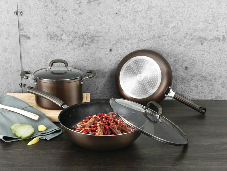 three pots and a pan sitting on a table