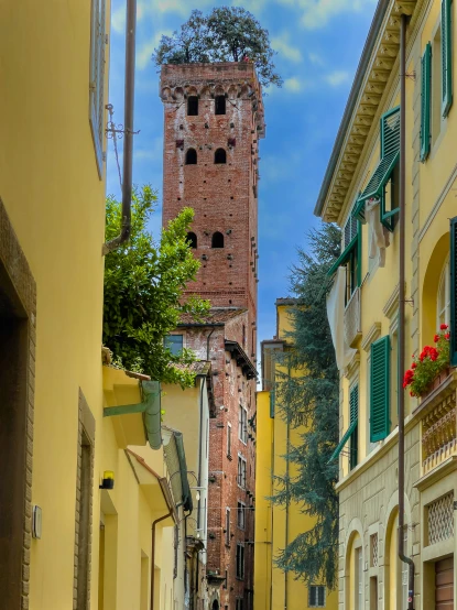 a narrow street with a brick tower behind it