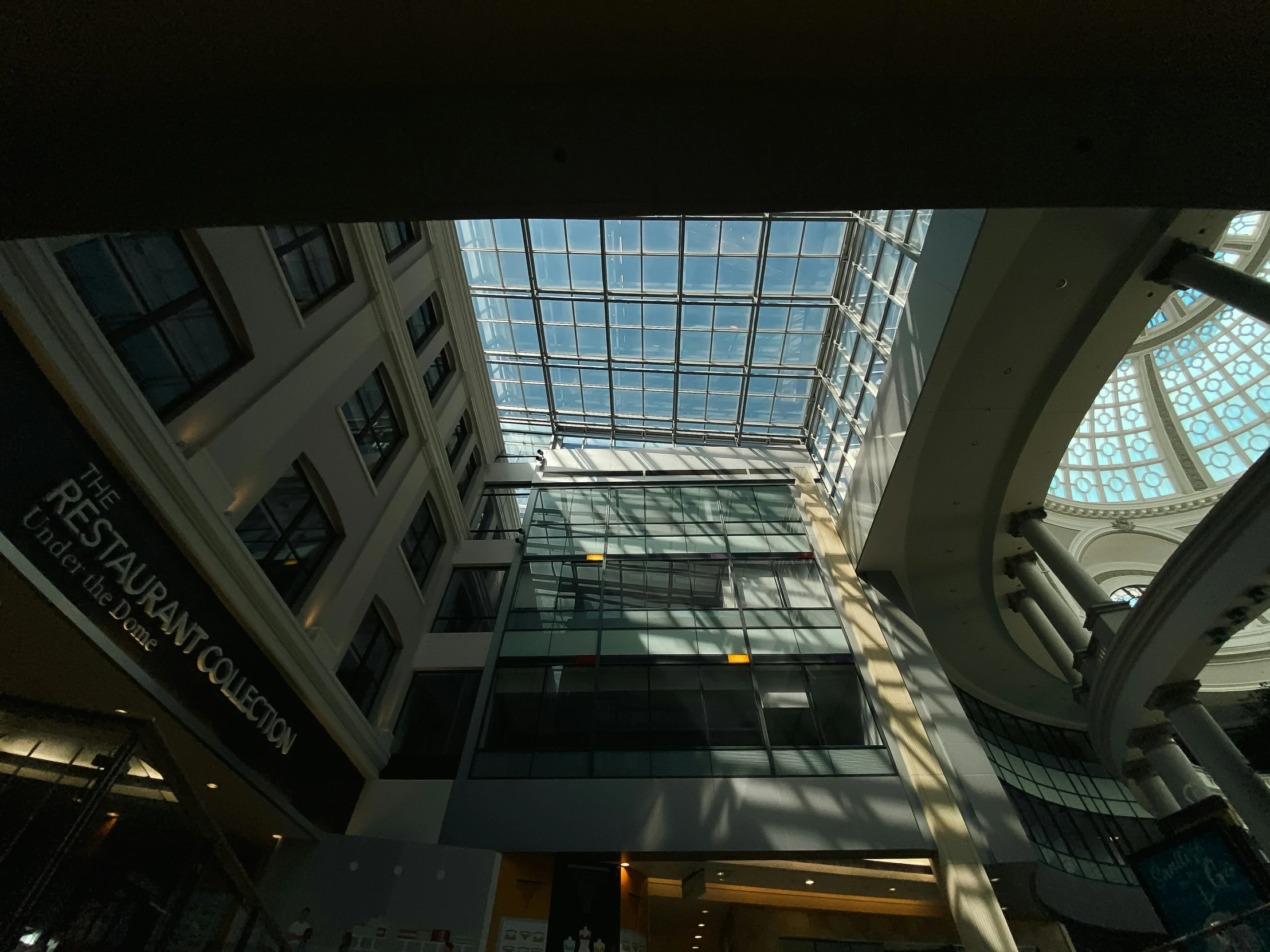 looking up at a building's high glass roof