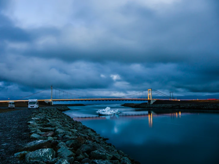 a body of water near a bridge in the evening