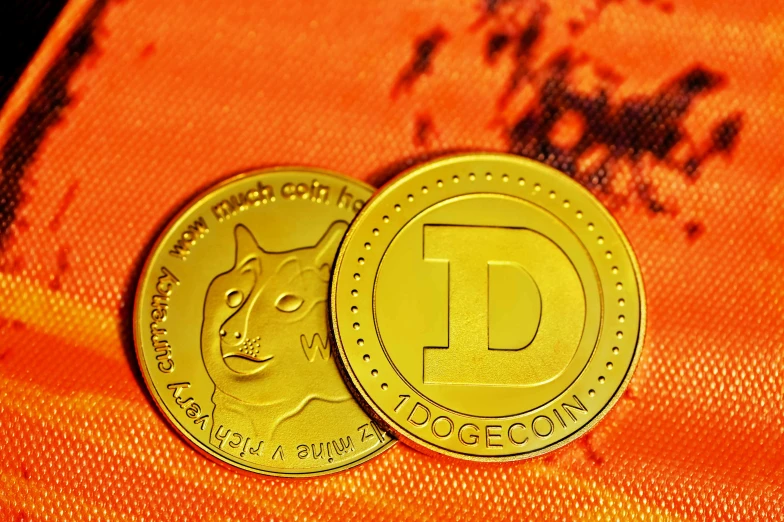 two golden coins sitting on an orange cloth